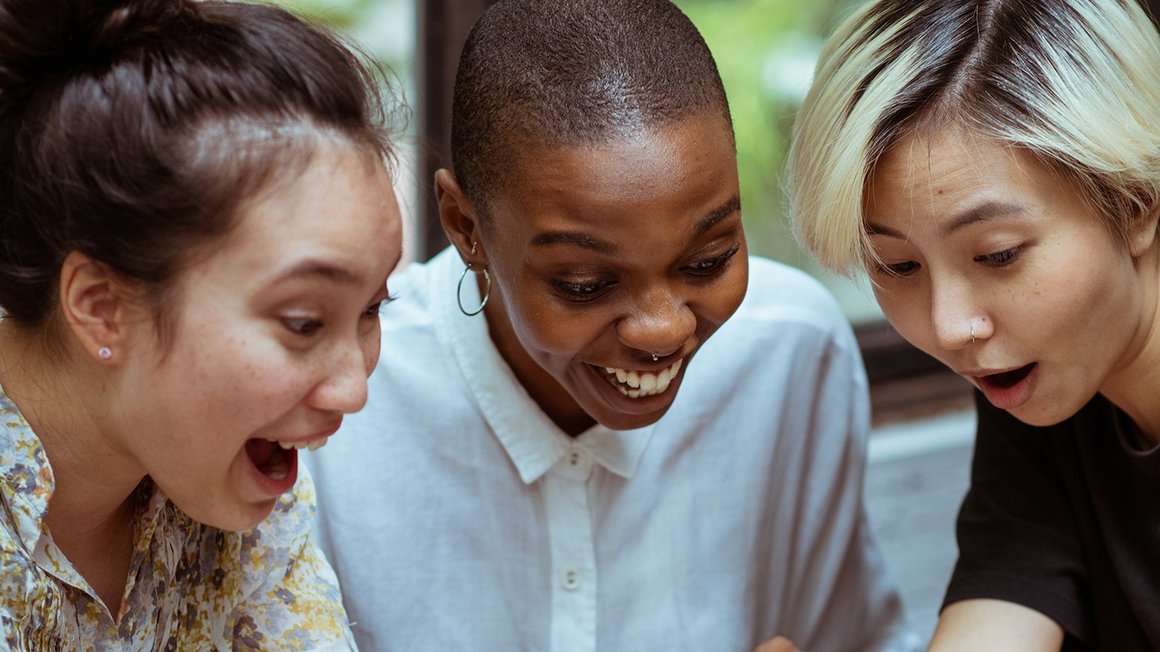 Drei Frauen lachen zusammen