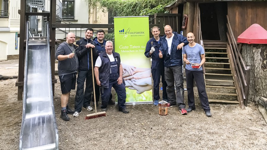 Ein Hausmeister und einige Helfer im Innenhof der Kita „Rosentalzwerge“