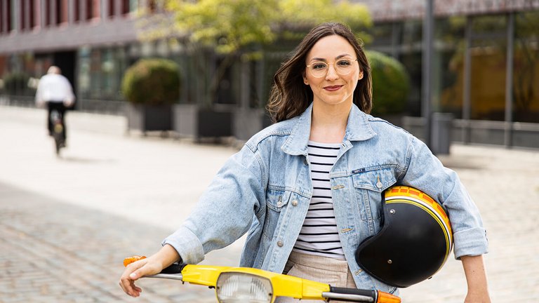 Junge Frau auf gelbem Roller OVB