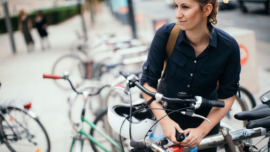 Fahrradversicherung: Frau schließt Fahrrad ab